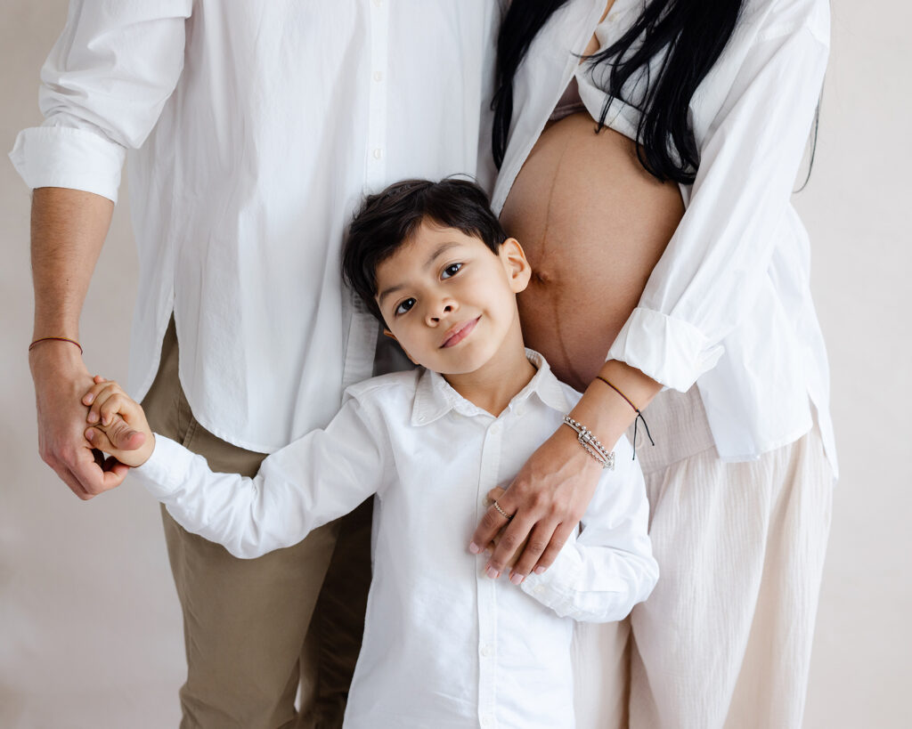 maternity photo of two parents with young child