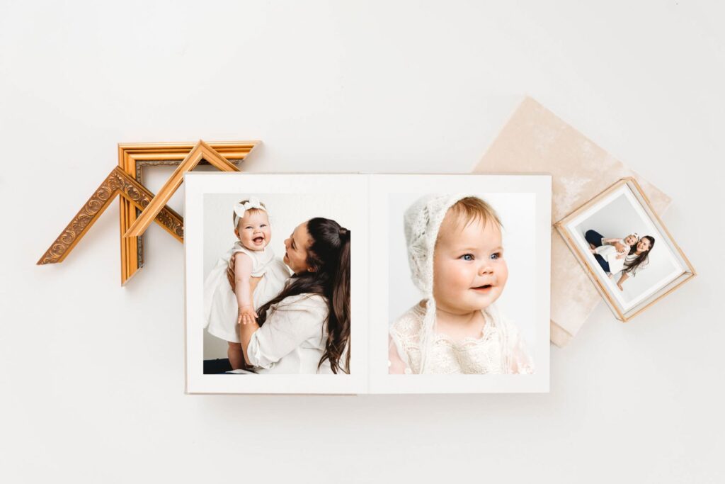 An open heirloom album featuring mother and baby girl portraits with vintage gold frame corners, captured by a Fort Collins newborn photographer.