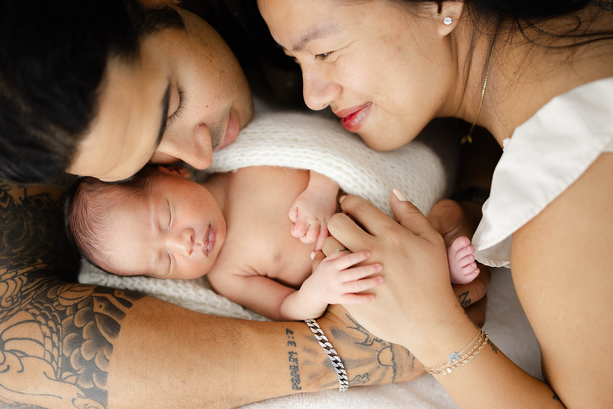 two new parents holding their newborn baby