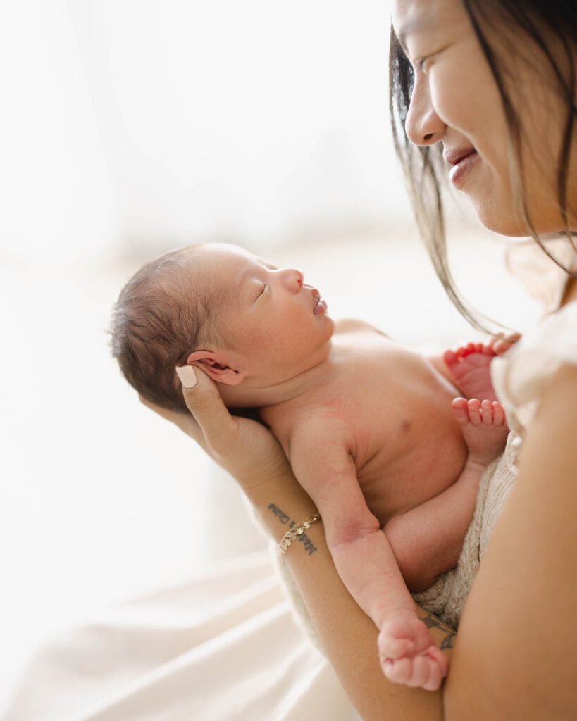 mother smiling at newborn baby