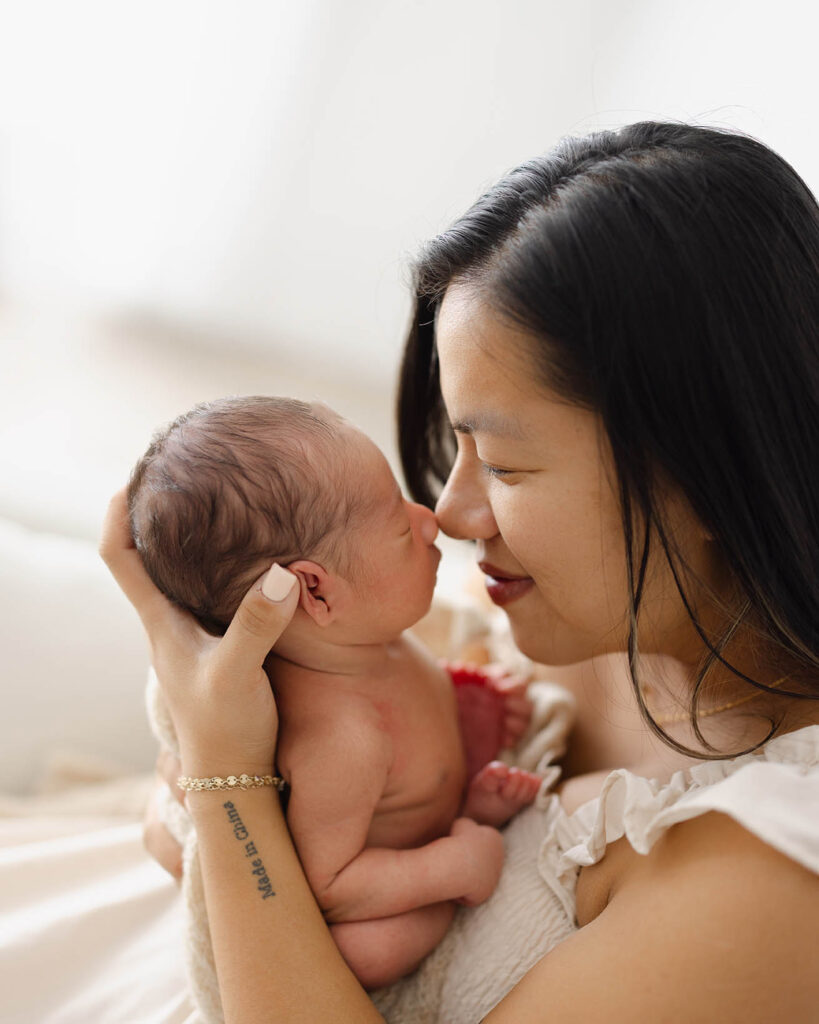 mom holding newborn baby close to face