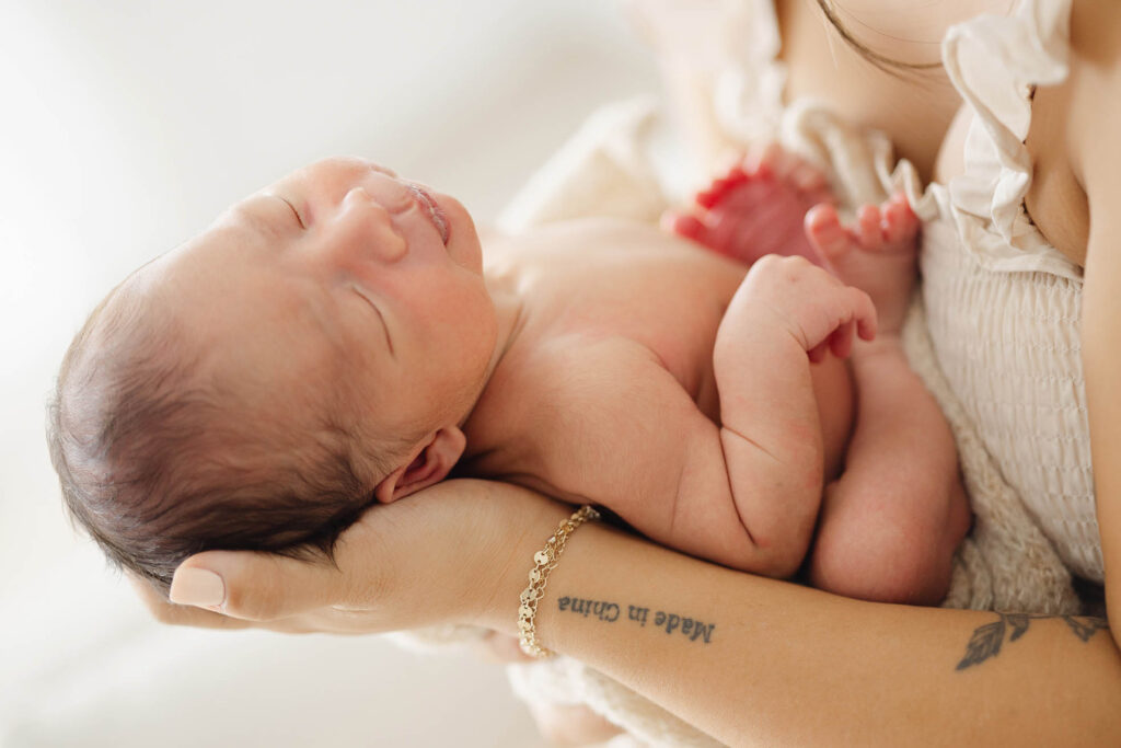 Newborn baby being held and cradled in mom's arms