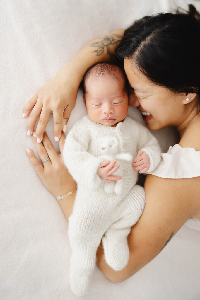 photo of mother cradling newborn baby between her two arms