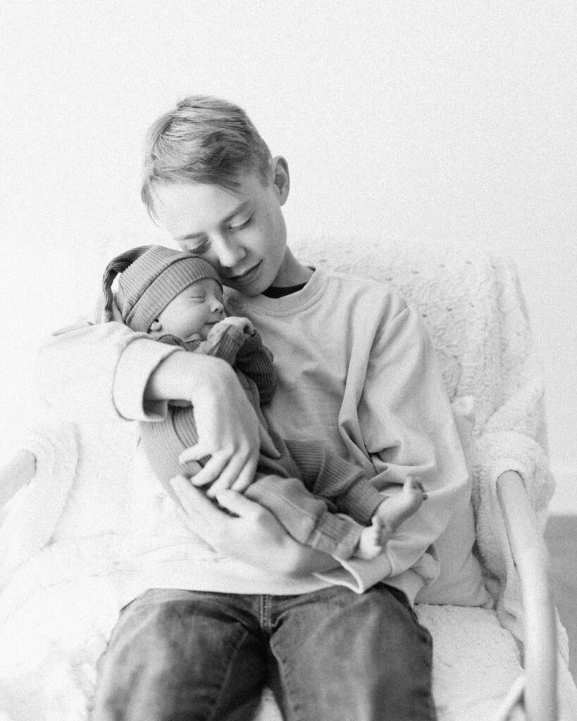 big brother holding newborn baby