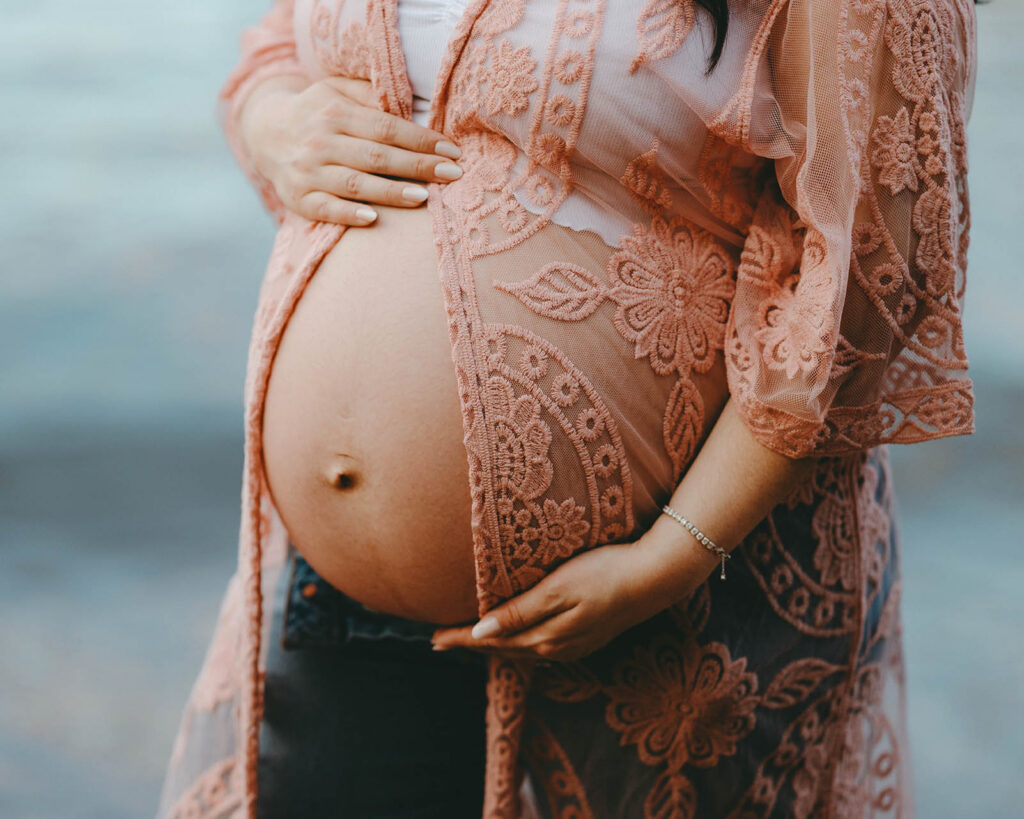 close-up photo of pregnant woman with top that opens in front, exposing her belly