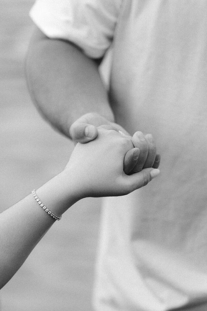 photo of husband's hand helping wife by her hand