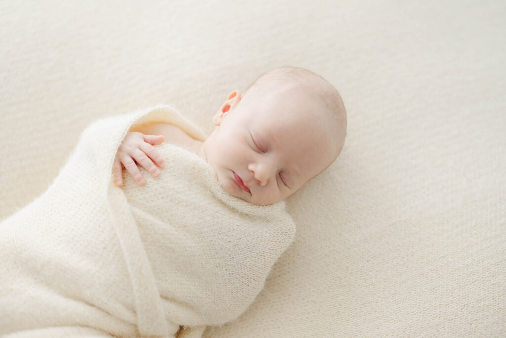 photo of newborn baby gently weapped in neutral wrap