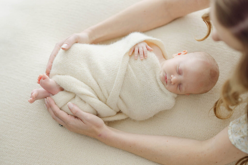 photo of mother's arms around newborn baby