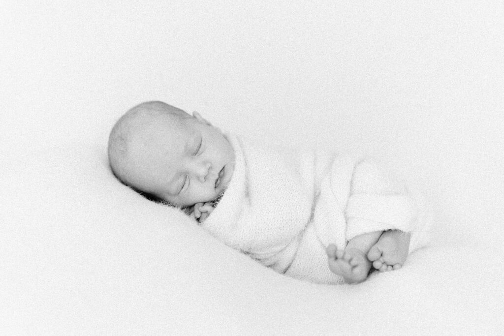 posed photo of newborn baby in creamy wrap