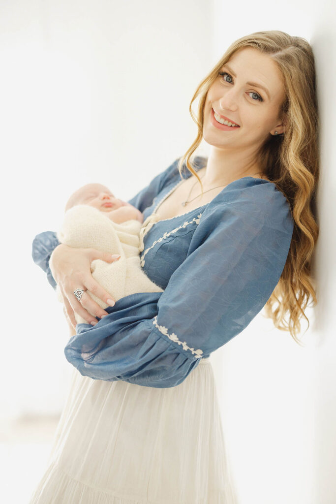 photo of mother holding newborn baby and looking diretly into the camera