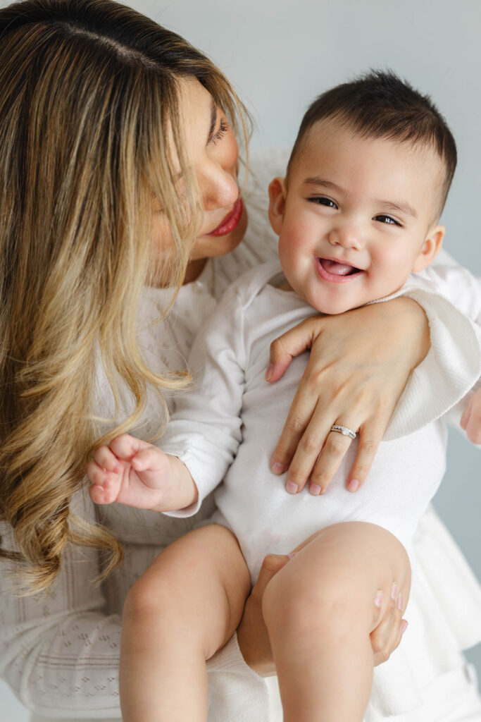 close-up of smiling baby in mother’s arms, natural studio motherhood session, Fort Collins baby photographer