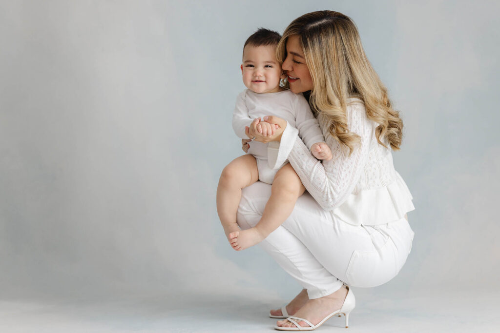 mother cuddling smiling baby photo studio