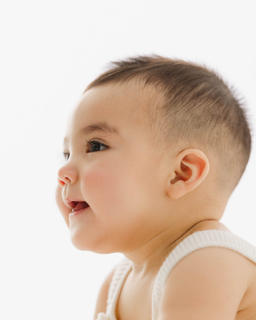 close up side profile of baby with soft light showing cheeks and eyelashes during milestone session