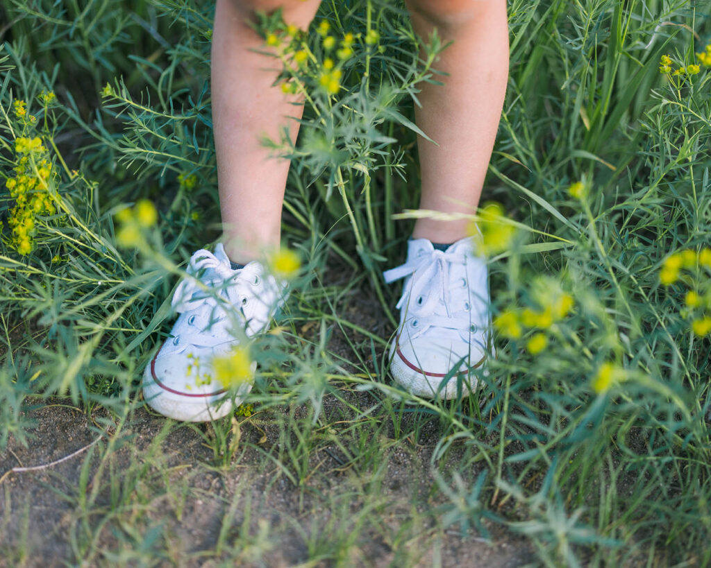 photo of a childs feet with flowers in summer