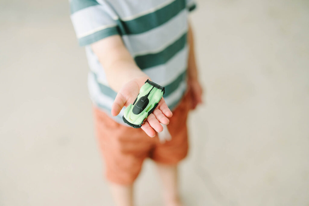 a small boy holding a toy car in his hand