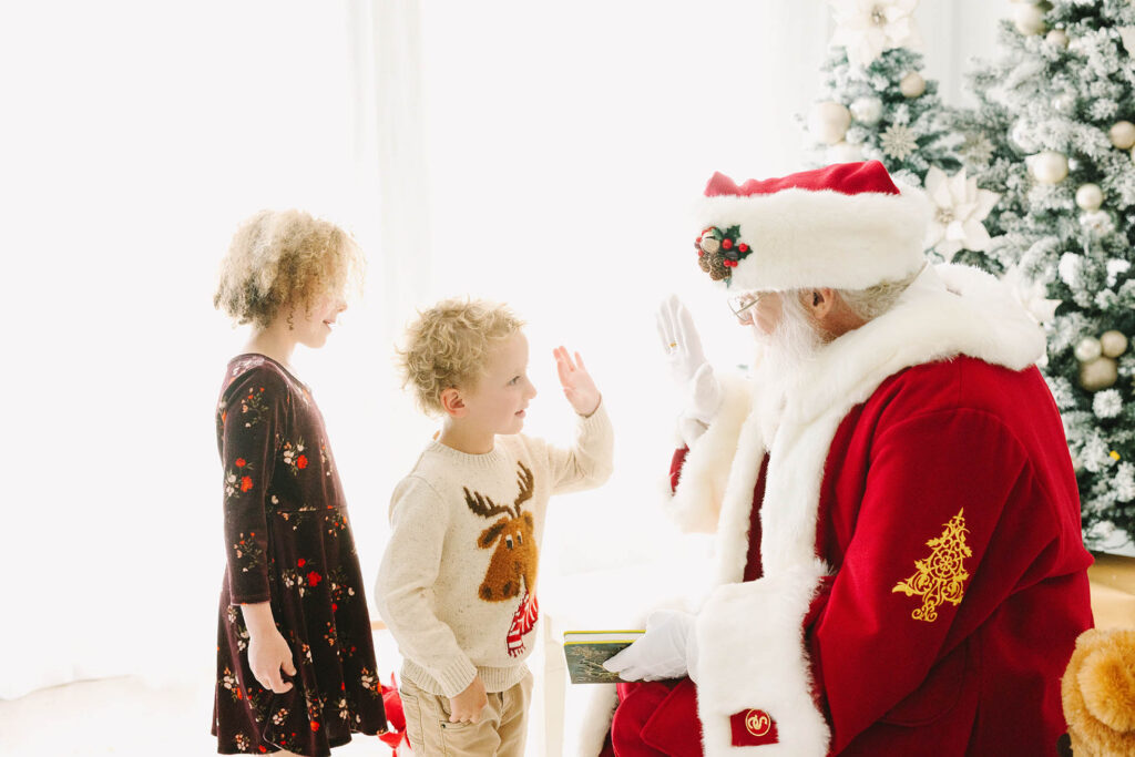 Santa high-fivinf a little boy