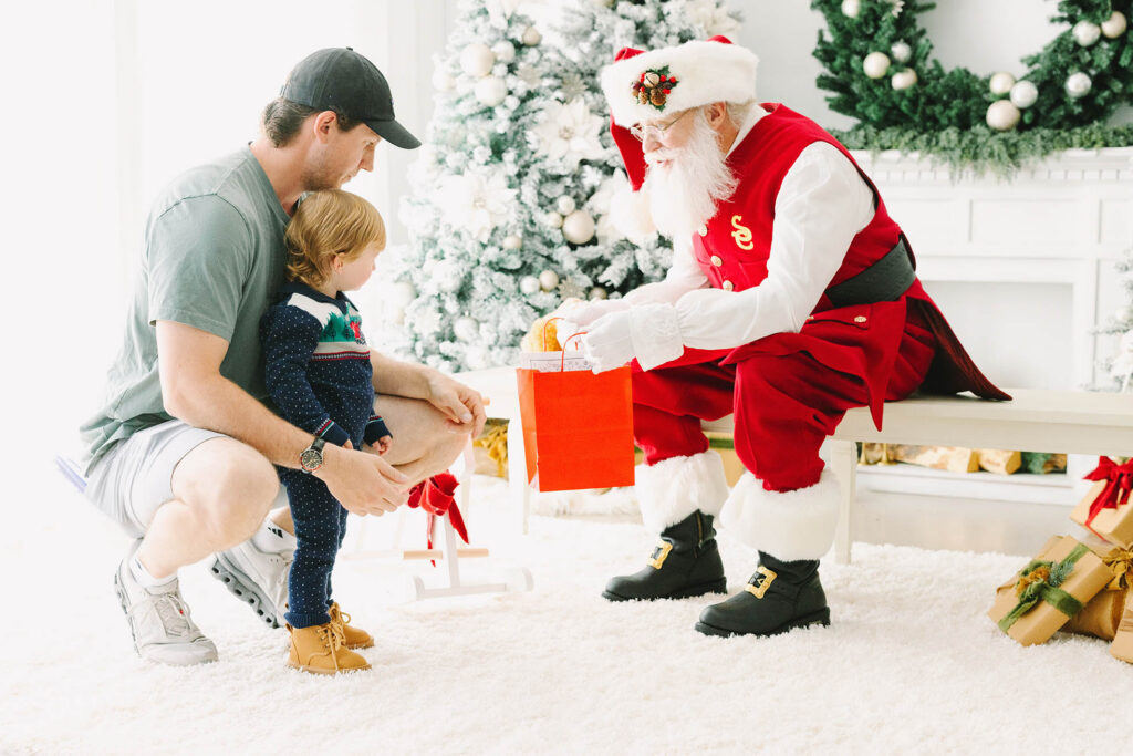 Santa giving a timid child a gift