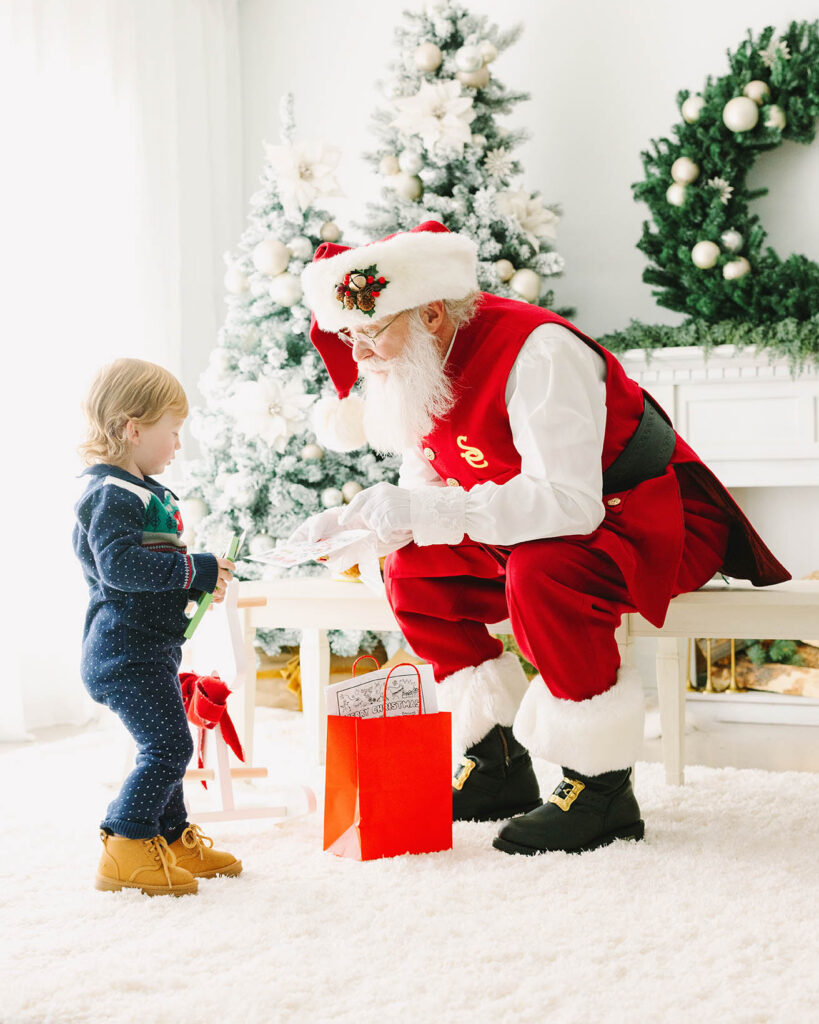 Santa showing a toddler boy his present