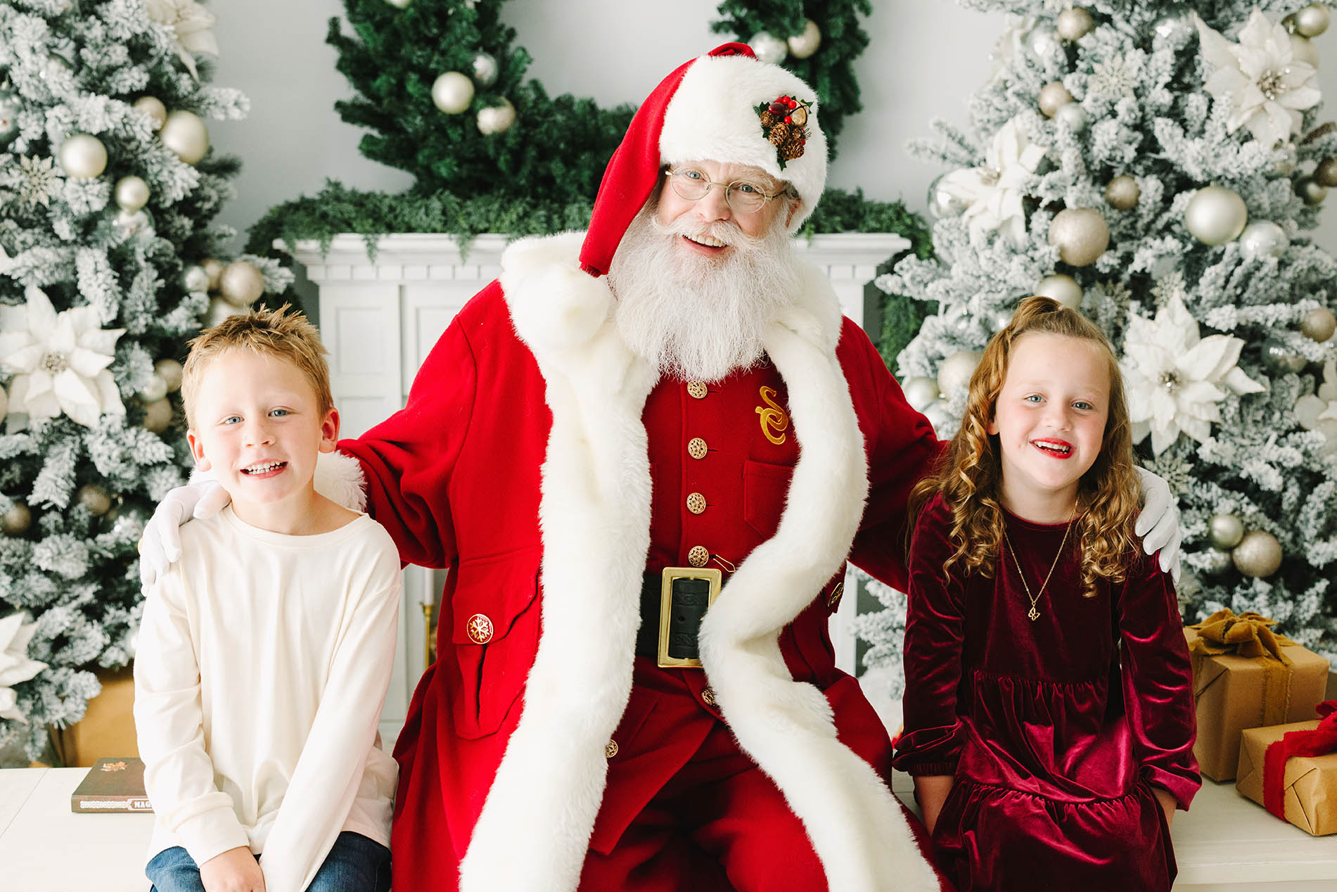 two children having their picture taken with Santa