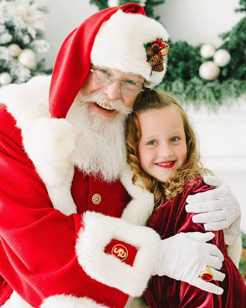 A little girl getting a hug from Santa